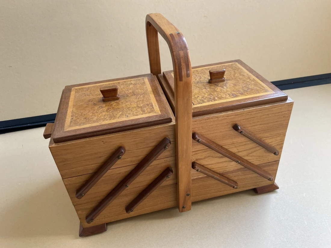 Der Nähkasten von der gegenüberliegenden Seite, mit warm getöntem Holz und kurzen Füßen.